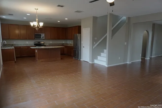 a open kitchen with kitchen island a sink stainless steel appliances and cabinets