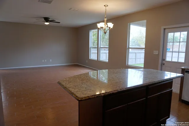 an open kitchen with a sink and chandelier