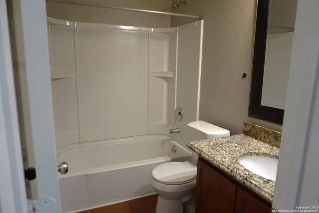 a bathroom with a granite countertop sink toilet and shower