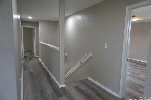a view of hallway with stairs and wooden floor
