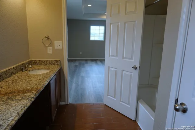 a bathroom with a granite countertop sink and a mirror