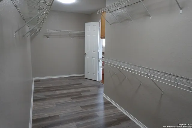 a view of walk in closet with wooden floor