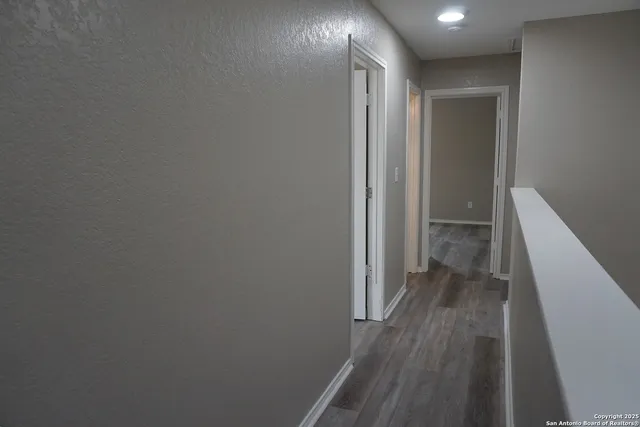 a view of a hallway with wooden floor