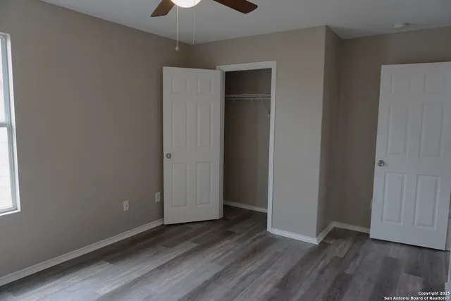 an empty room with wooden floor and closet