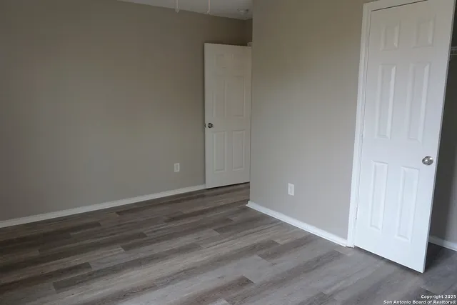 a view of an empty room with wooden floor