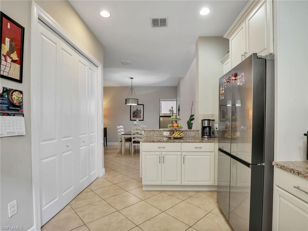 1242 Kendari Terrace Naples, FL 34113 - Photo 15 of 44 a kitchen with a sink appliances and cabinets