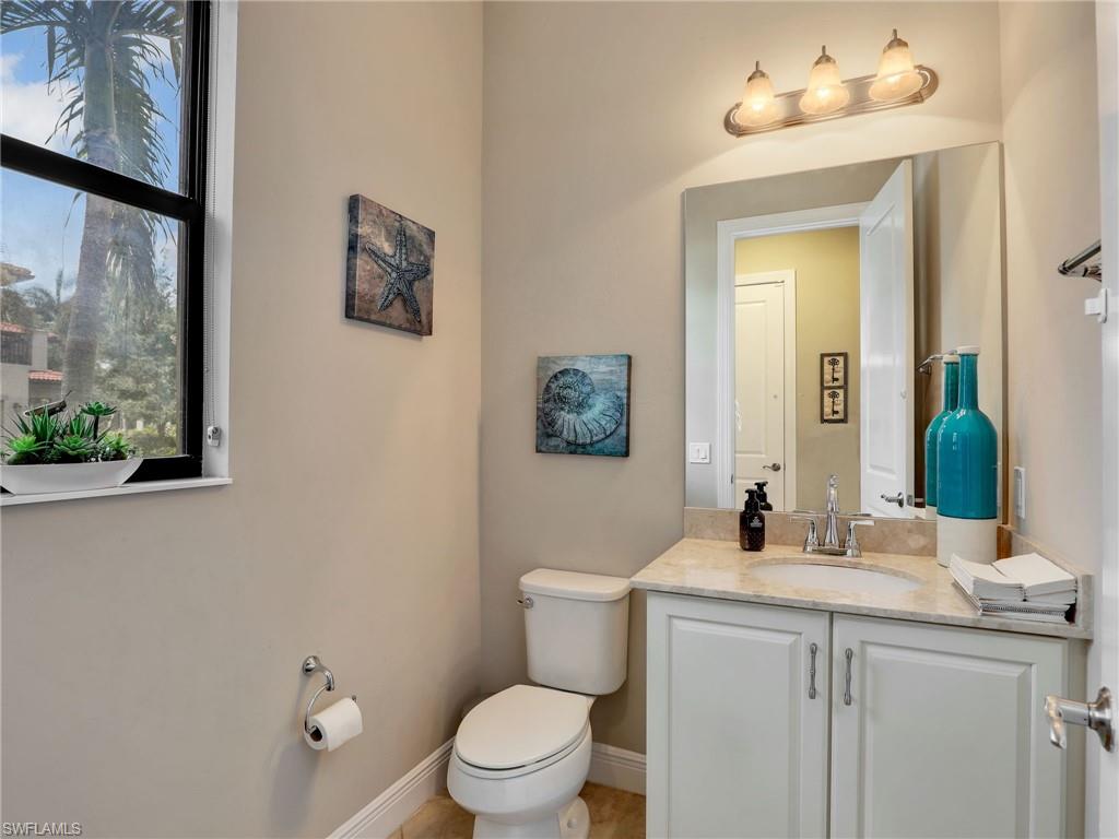 1242 Kendari Terrace Naples, FL 34113 - Photo 17 of 44 a bathroom with a toilet sink and mirror