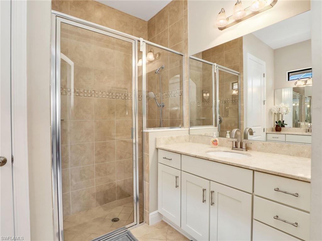 1242 Kendari Terrace Naples, FL 34113 - Photo 20 of 44 a bathroom with a shower sink and mirror