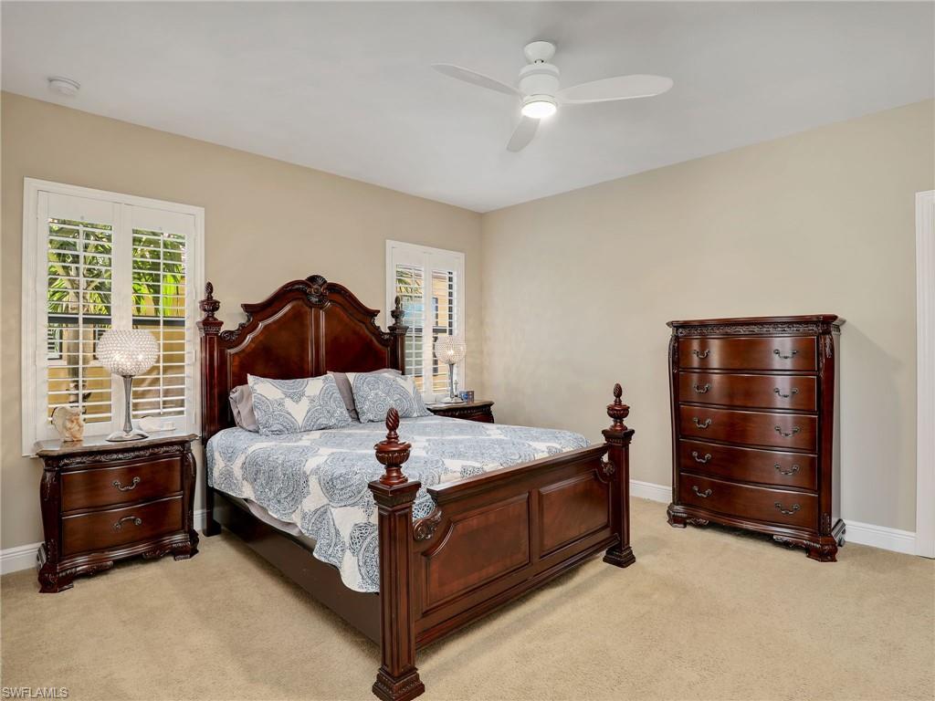 1242 Kendari Terrace Naples, FL 34113 - Photo 25 of 44 a bedroom with a bed and a ceiling fan