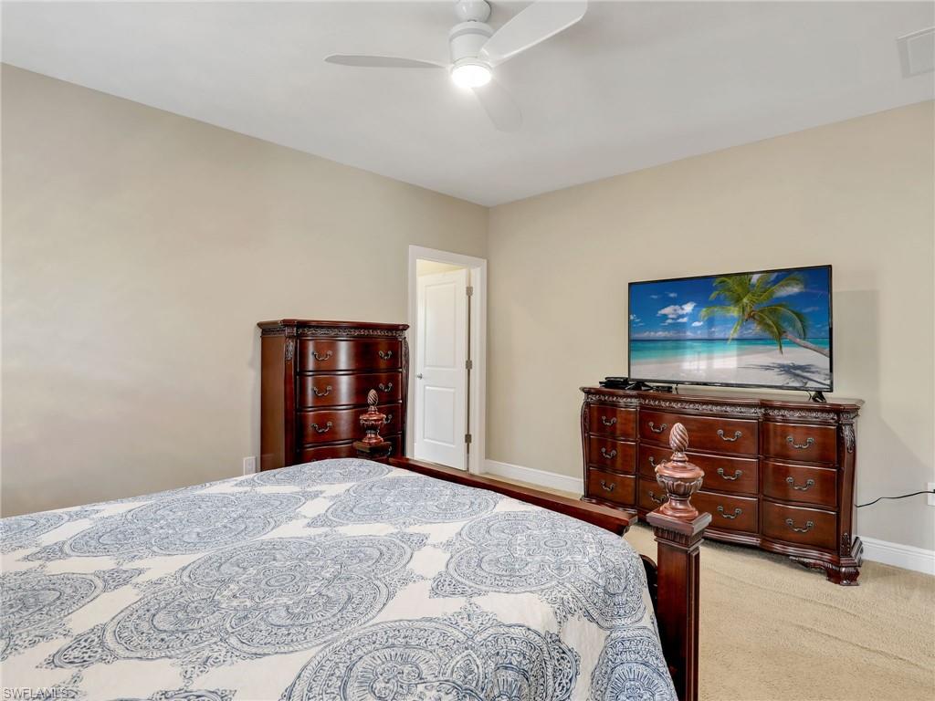 1242 Kendari Terrace Naples, FL 34113 - Photo 26 of 44 a bedroom with a bed and a flat screen tv