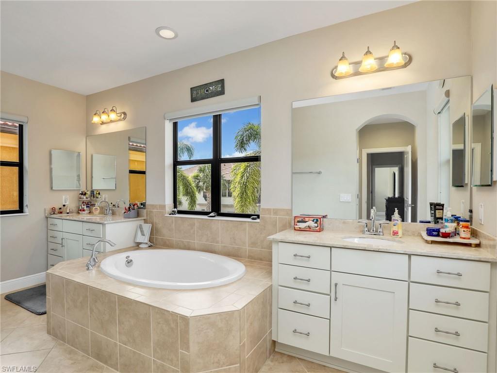 1242 Kendari Terrace Naples, FL 34113 - Photo 27 of 44 a bathroom with a tub sink and mirror