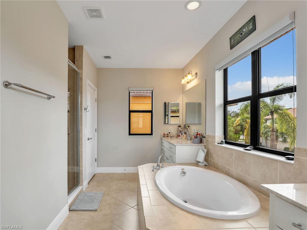 1242 Kendari Terrace Naples, FL 34113 - Photo 28 of 44 a spacious bathroom with a large tub and large window
