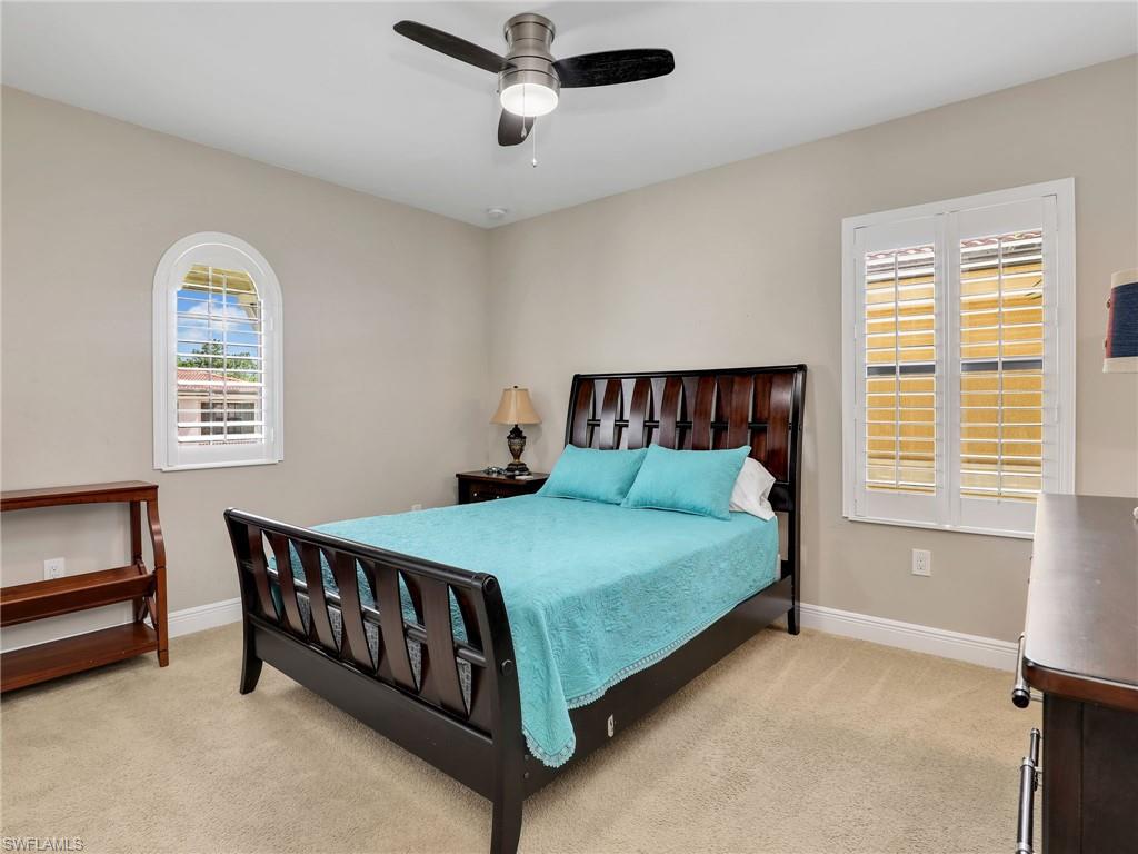 1242 Kendari Terrace Naples, FL 34113 - Photo 30 of 44 a bed sitting in a bedroom next to a window