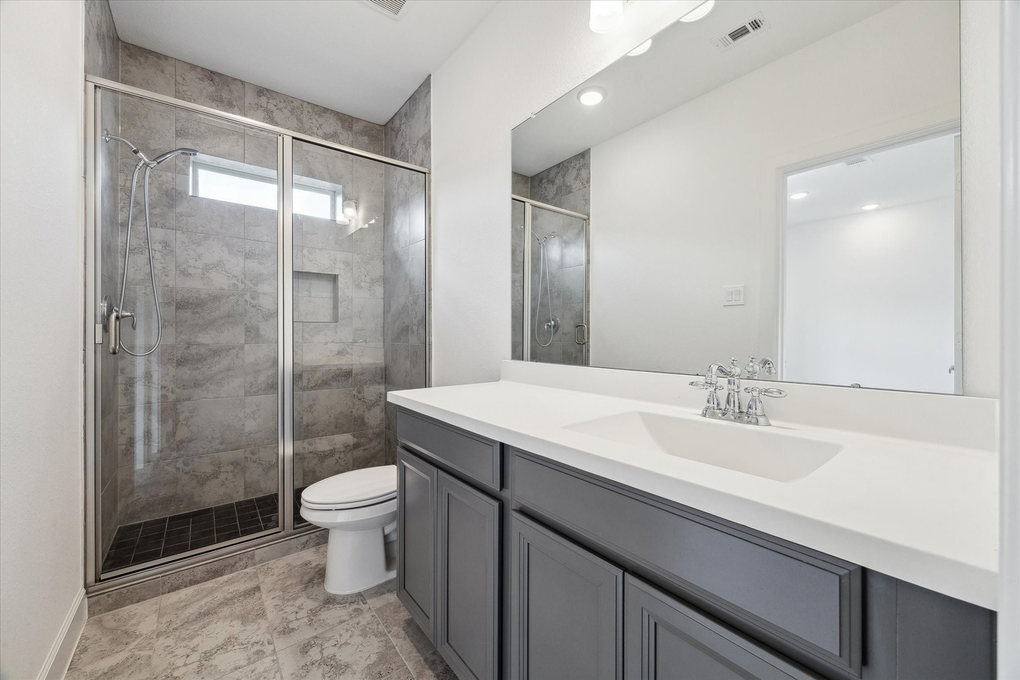 2714 Strathwood Lane Houston, TX 77082 - Photo 16 of 35 Attached to the versatile first and second bedrooms is a well-appointed secondary bathroom, featuring a sophisticated walk-in shower. This setup is ideal for guests with the modern convenience of a walk-in glass shower.