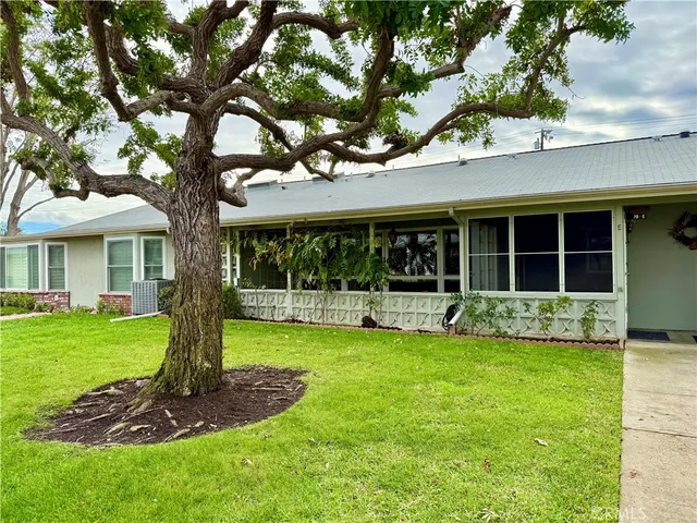 a front view of a house with a yard garden and porch