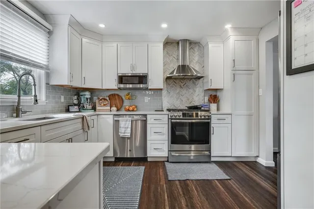 a kitchen with a white stove top oven and cabinets