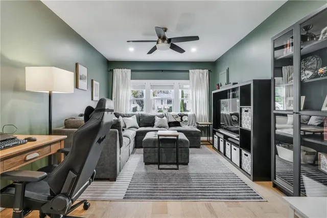 a living room with furniture a flat screen tv and a table