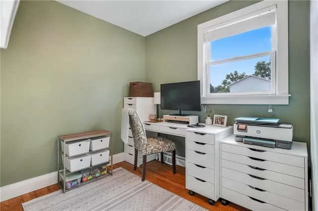 a view of a workspace with furniture and wooden floor