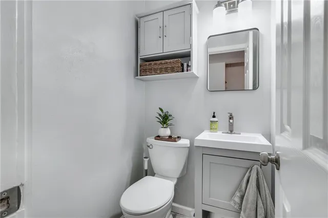 a bathroom with a toilet a sink and a mirror