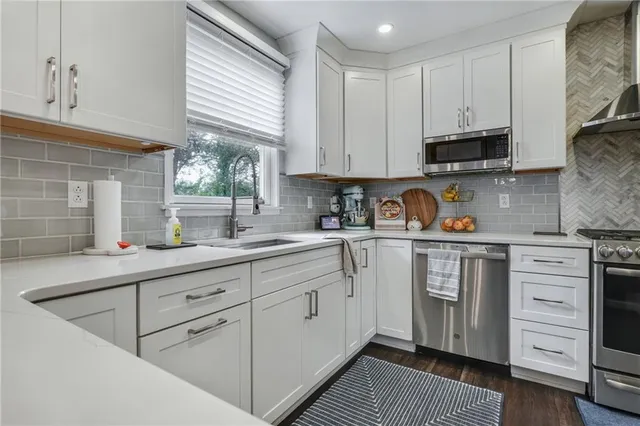 a kitchen with cabinets appliances a sink and a window