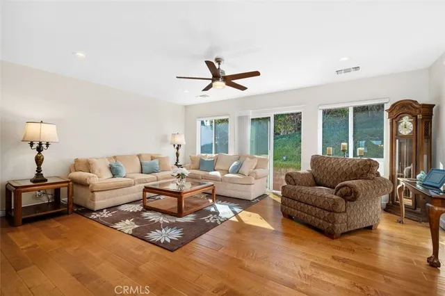 a living room with furniture ceiling fan and a large window