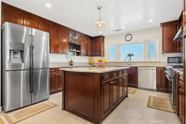 a kitchen with stainless steel appliances granite countertop a refrigerator a stove a sink a oven and a refrigerator