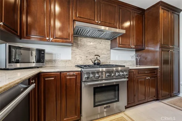 a kitchen with granite countertop wooden cabinets and stainless steel appliances