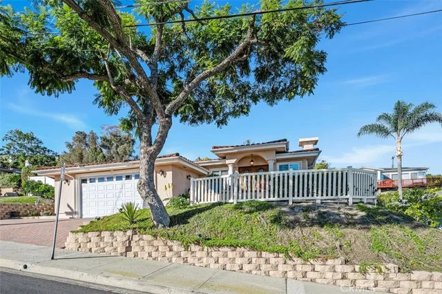 a view of a house with a small yard and wooden fence
