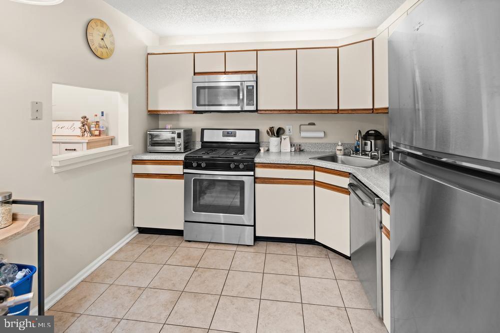 52 Willow Court Hamilton, NJ 08619 - Photo 7 of 23 a kitchen with a stove a sink and a refrigerator