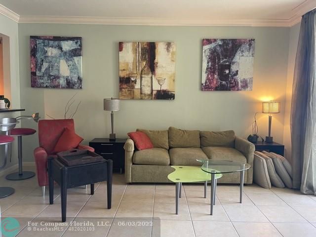 a living room with furniture a couch and paintings on wall