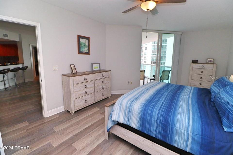 231 Riverside Drive, Unit 11061 Daytona Beach, FL 32117 - Photo 11 of 45 a bedroom with a bed and a chandelier