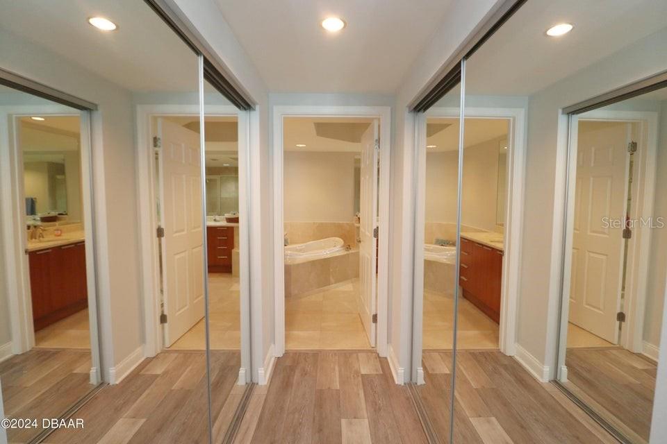 231 Riverside Drive, Unit 11061 Daytona Beach, FL 32117 - Photo 16 of 45 a view of a hallway with wooden floor and a bathroom