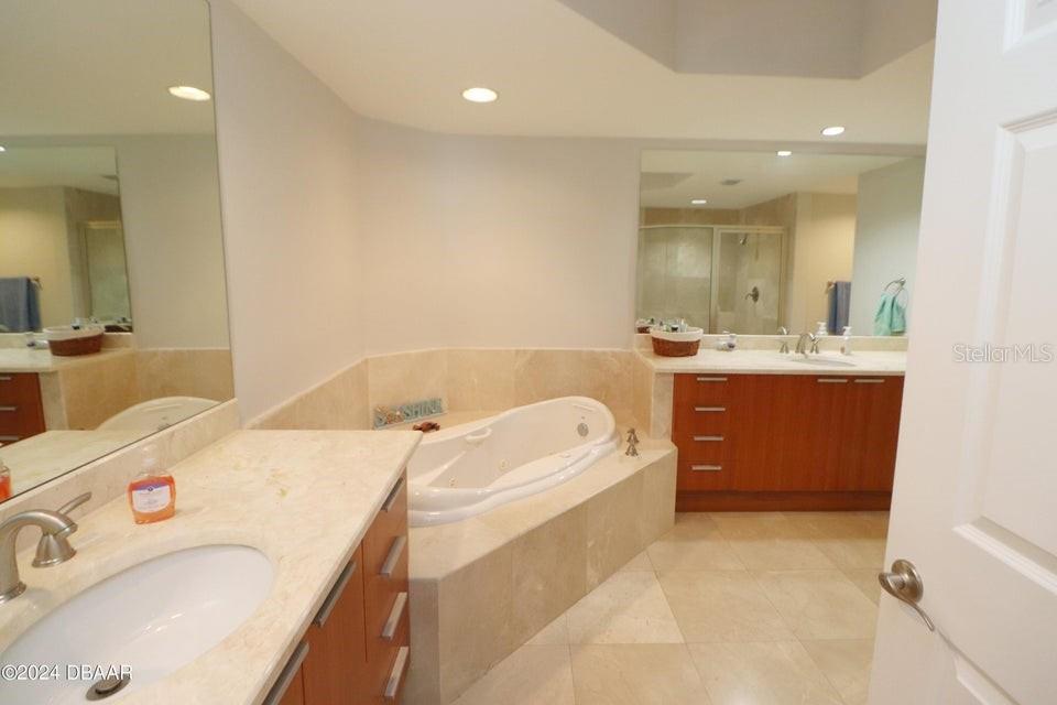 231 Riverside Drive, Unit 11061 Daytona Beach, FL 32117 - Photo 17 of 45 a bathroom with a tub sink and mirror