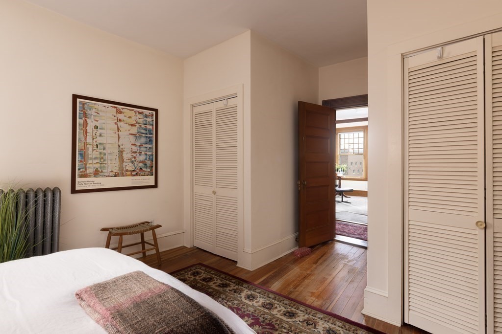 367 Harvard Street, Unit 3 Brookline, MA 02446 - Photo 11 of 25 a bedroom with a bed and wooden floor
