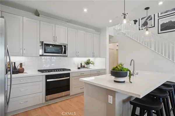 a kitchen with white cabinets and stainless steel appliances