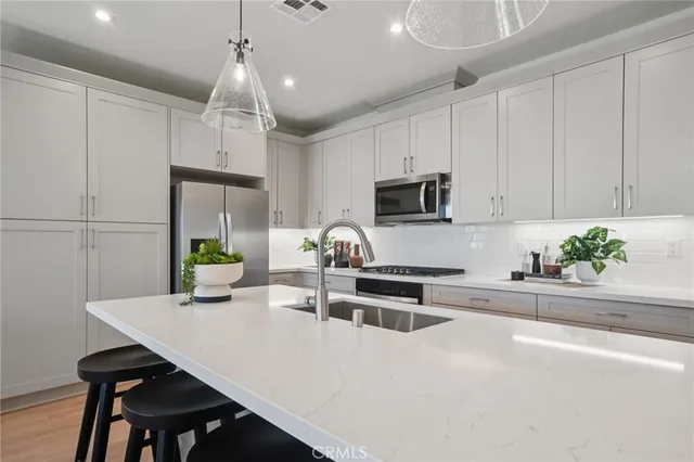 a kitchen with stainless steel appliances a table chairs and a refrigerator
