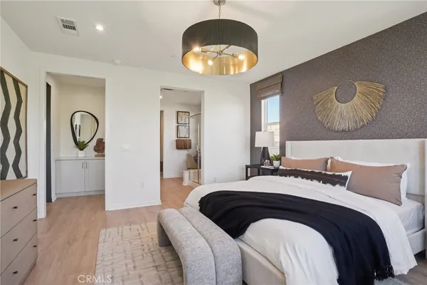 a bedroom with a bed and a chandelier