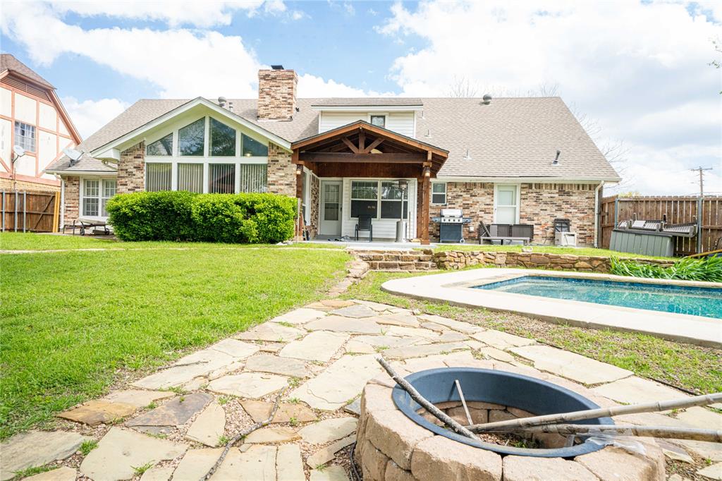 919 Green Hills Road Duncanville, TX 75137 - Photo 35 of 37 Back of house featuring an outdoor fire pit, a chimney, brick siding, and a shingled roof