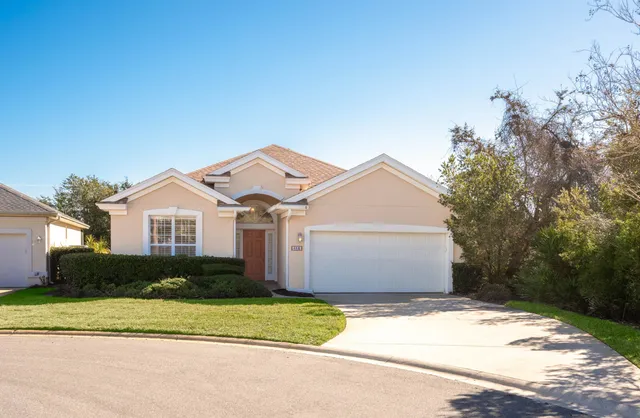 a front view of a house with a garden and yard