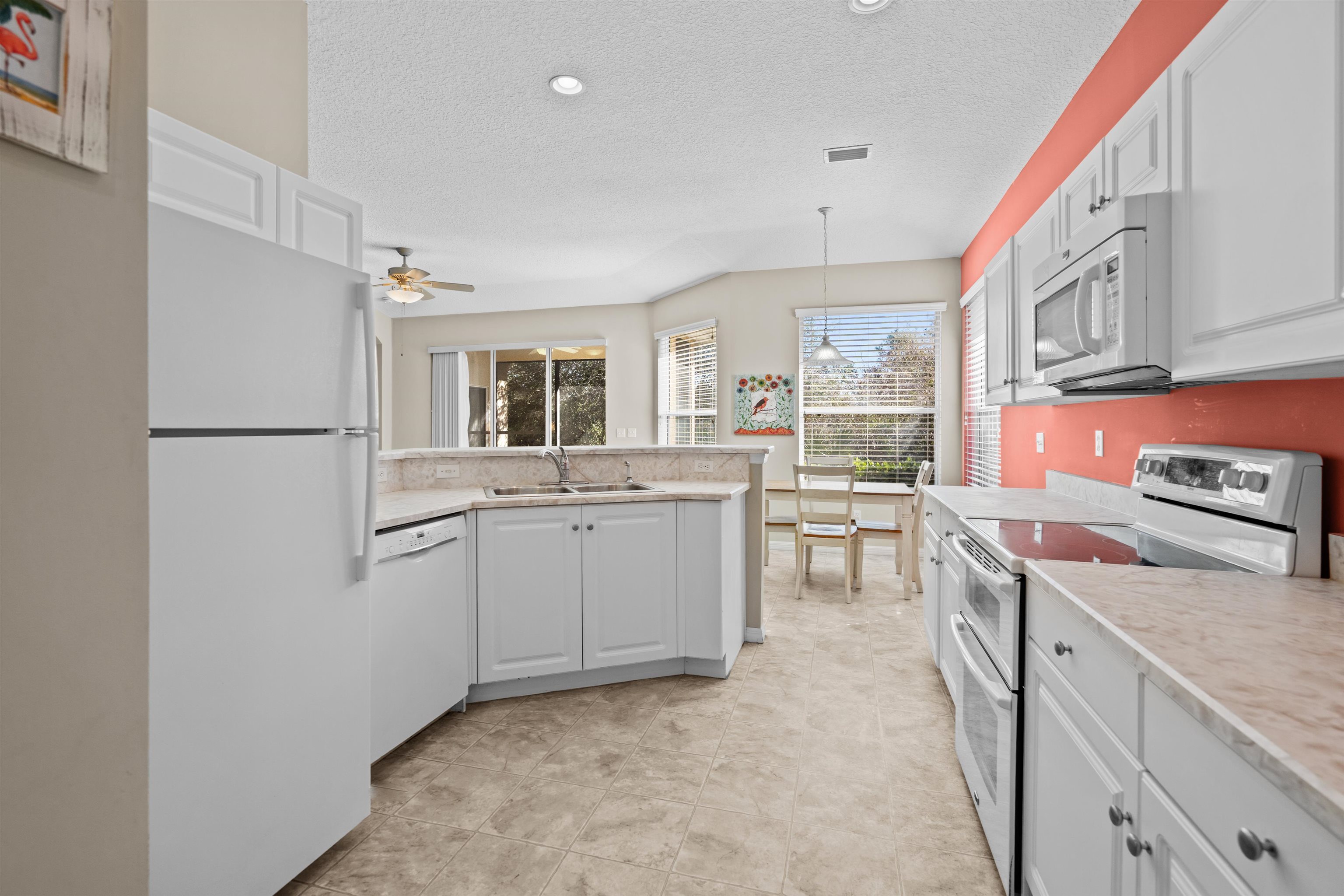 660 Casa Fuerta Lane St. Augustine, FL 32080 - Photo 15 of 52 Kitchen featuring white appliances, light countertops, white cabinets, pendant lighting, and a textured ceiling