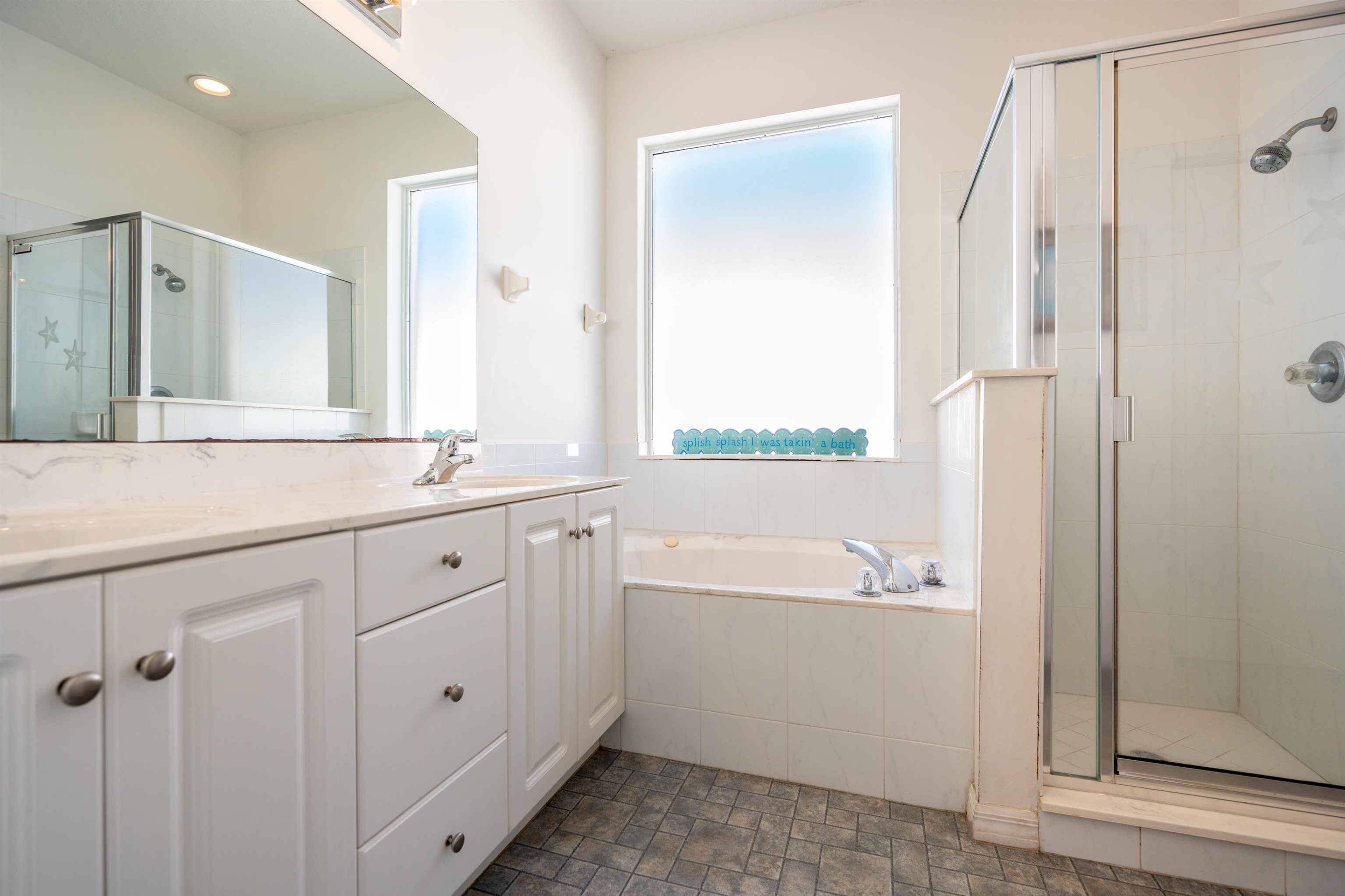 660 Casa Fuerta Lane St. Augustine, FL 32080 - Photo 2 of 52 a bathroom with a double vanity sink a mirror a bathtub and shower