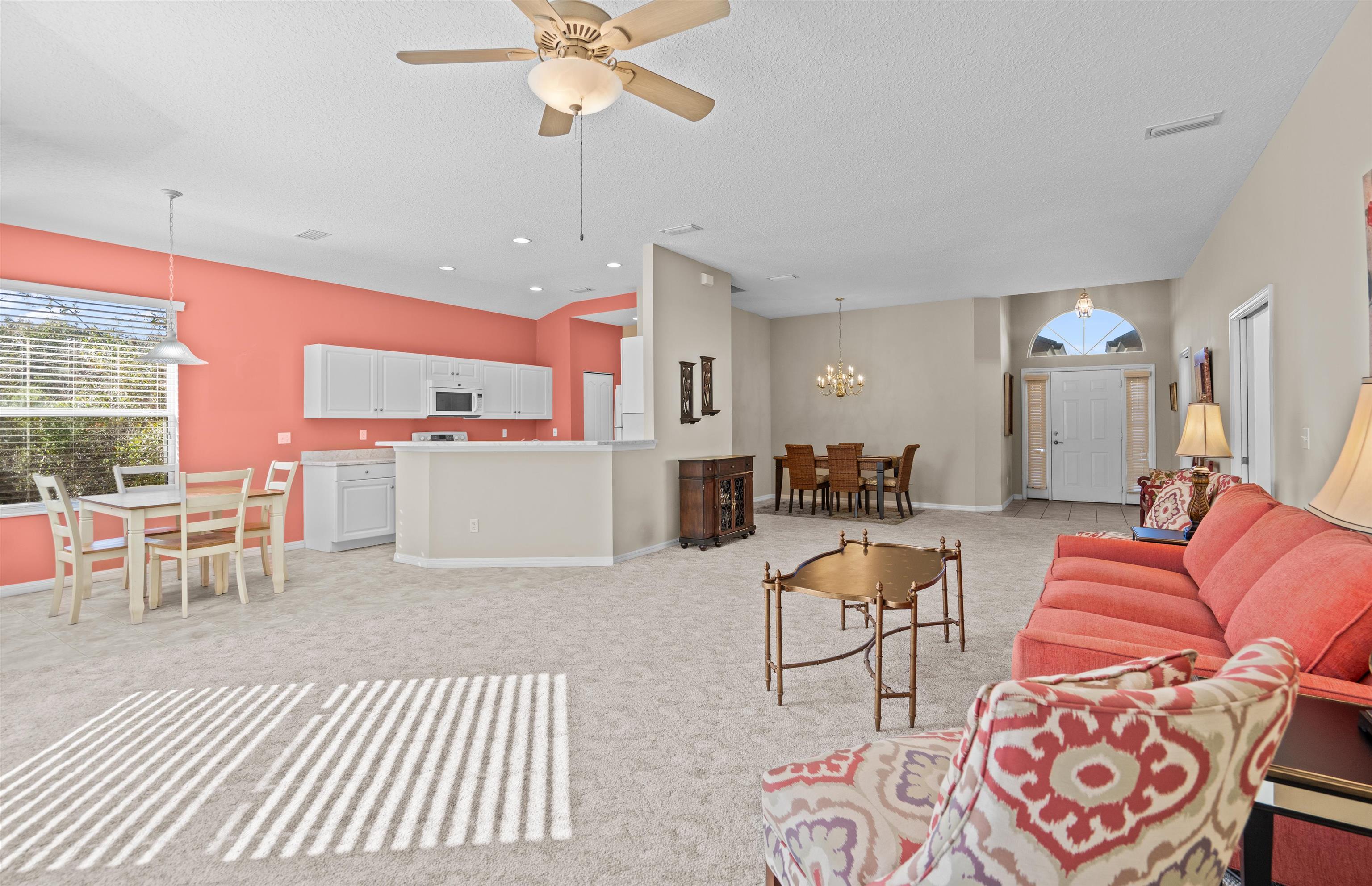 660 Casa Fuerta Lane St. Augustine, FL 32080 - Photo 8 of 52 Living room with a ceiling fan, a textured ceiling, light carpet, and suspended lighting