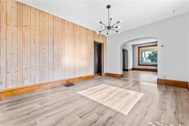 a view of a room with wooden floor and entryway