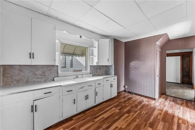 a kitchen with sink cabinets and wooden floor