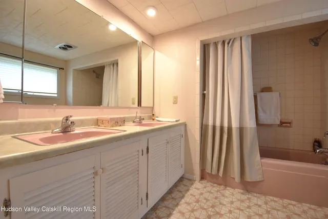a bathroom with a double vanity sink and a mirror