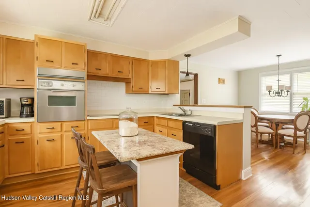 a kitchen with a stove a sink a dining table and chairs