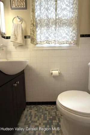 a bathroom with a sink a toilet and a mirror