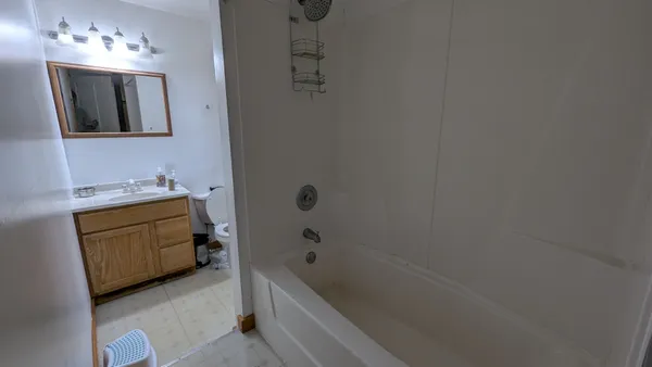a bathroom with a tub sink and mirror