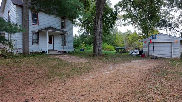 a view of a house with a yard and large tree