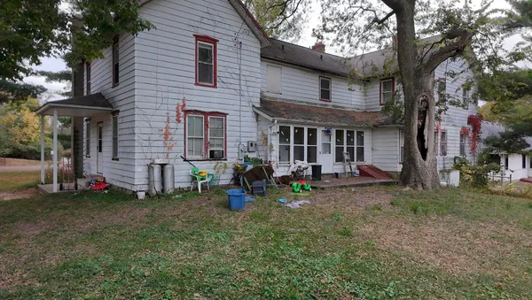 a view of a brick house with many windows and a large tree